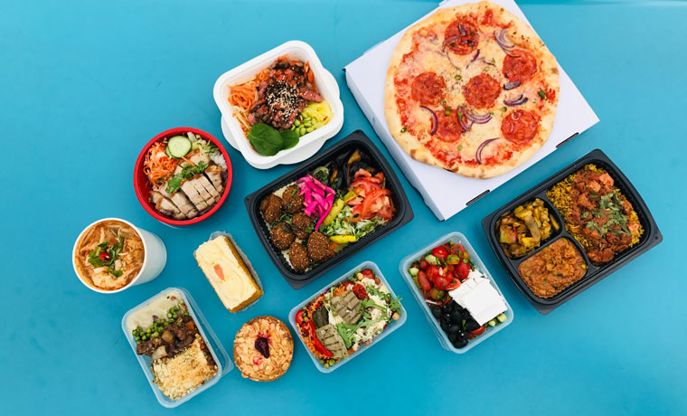 Flera take-away förpackningar med mat mot en blå bakgrund