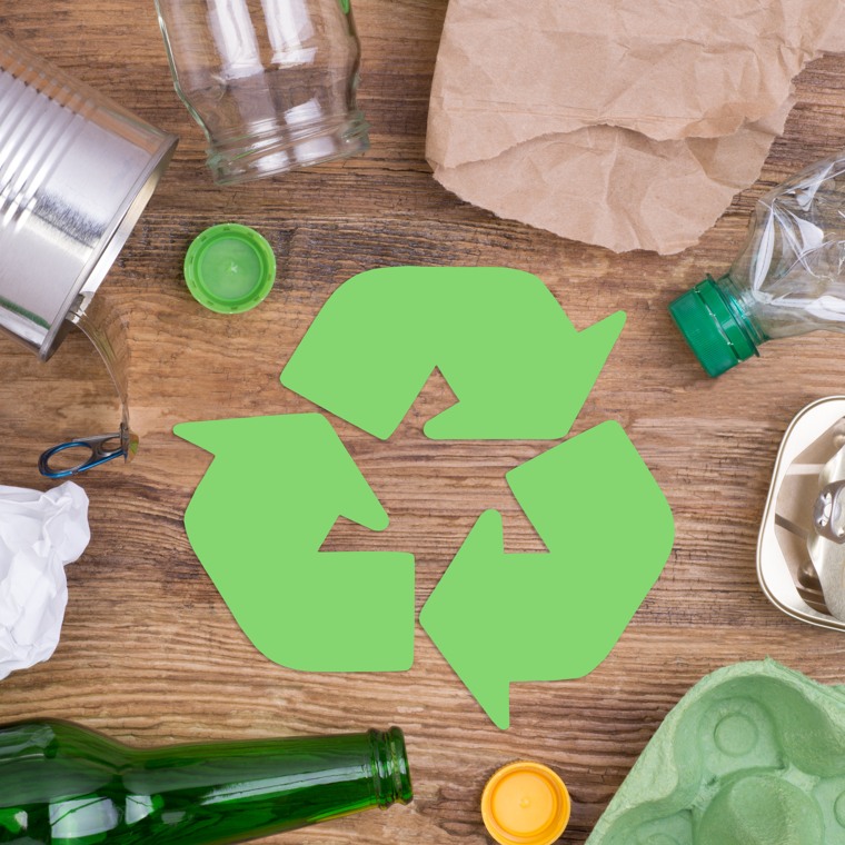 Tomma förpackningar mot en brun bakgrund med en grön återvinningssymbol i mitten.